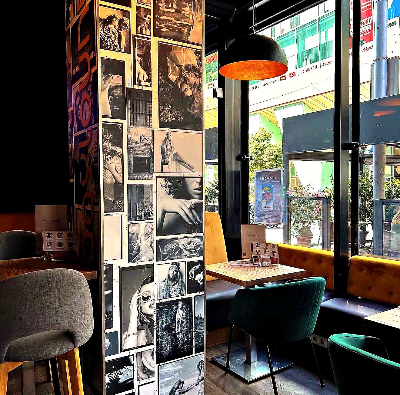 Säule mit Schwarz-Weiß-Fotos und dem daylounge-Schriftzug, daneben Tische am Fenster